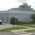 Rondale City Hall exterior, low gray brick civic building with entrance sign, parking, sidewalk and manicured landscaping